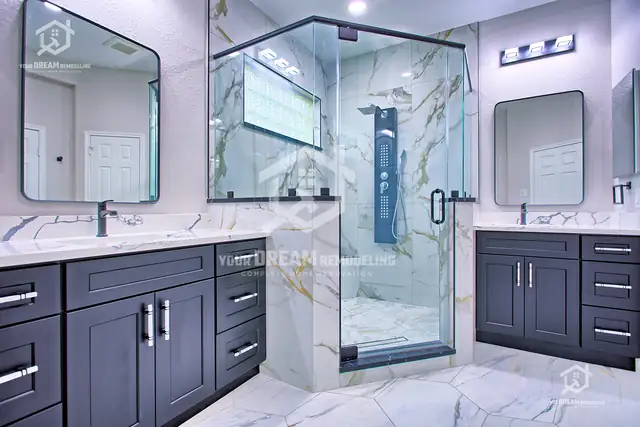 Master bath with two charcoal shaker vanities, quartz tops, black-framed mirrors and a glass shower between them